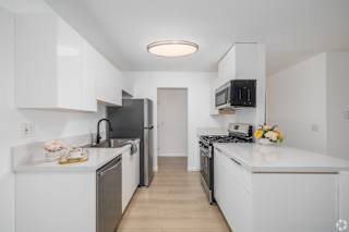 A kitchen with white cabinets and appliances.