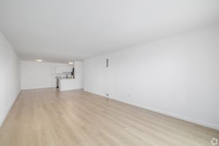 A room with wooden flooring and white walls.