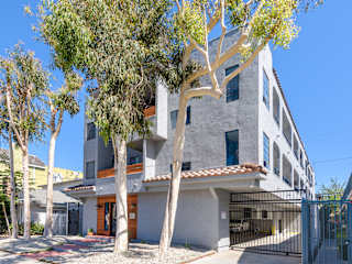 A modern house with a grey exterior and a black gate.