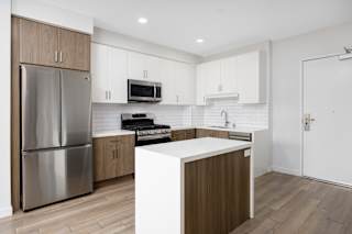 a kitchen with white cabinets and stainless steel appliances