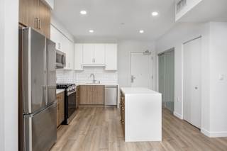 a renovated kitchen with white cabinets and stainless steel appliances