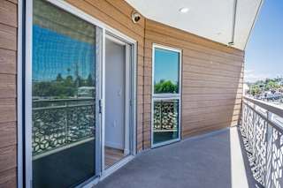 a balcony with glass doors and a view of the city
