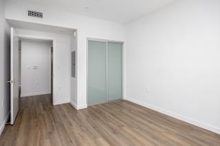 an empty room with white walls and a sliding glass door
