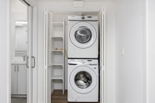 a white washer and dryer in a white laundry room