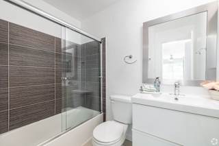 A white toilet sits next to a sink in a bathroom.