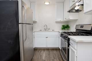 a white kitchen with stainless steel appliances and white cabinets