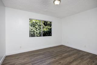 an empty room with white walls and a window