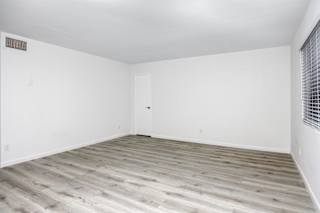 an empty room with white walls and wood floors