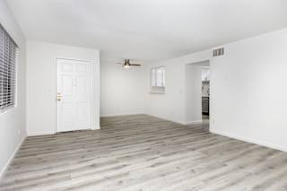 an empty living room with white walls and a white door