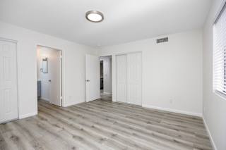 an empty living room with white walls and wood flooring