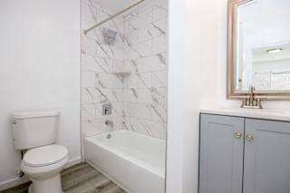 a bathroom with a toilet and a tub and a sink