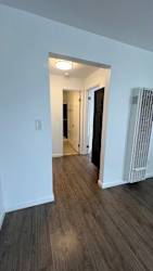 A room with a white wall and a wooden floor.