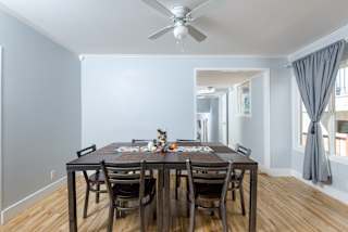 a dining room with a table and chairs and a ceiling fan