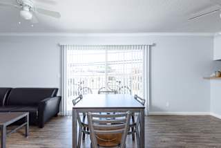 a living room with a dining room table and a large window
