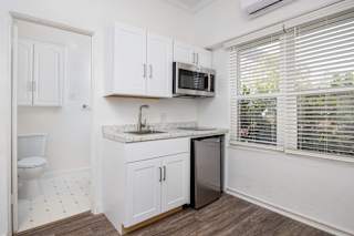 A kitchen with white cabinets and a marble countertop.