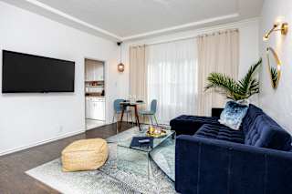 a living room with a blue couch and a tv