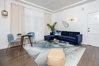 a living room with a blue couch and a glass coffee table