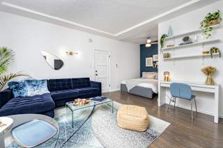 a living room with a couch and a table and a bed