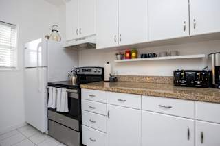 a kitchen with white cabinets and a counter top and a refrigerator