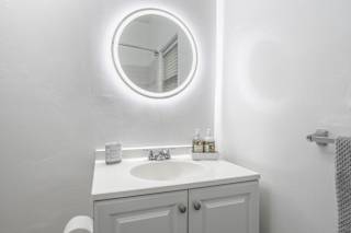 a white bathroom with a sink and a mirror