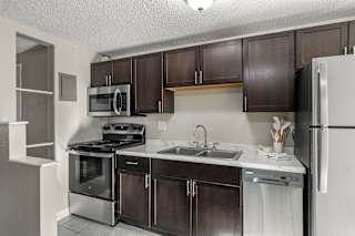 A kitchen with brown cabinets and a white refrigerator.