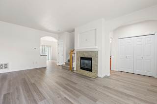 A living room with a fireplace and wood flooring.
