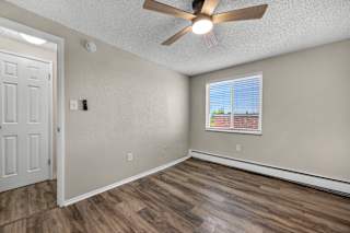 A room with a ceiling fan and a window with blinds.