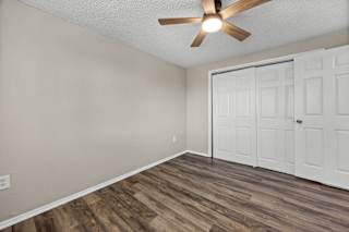 A room with a ceiling fan and a door.