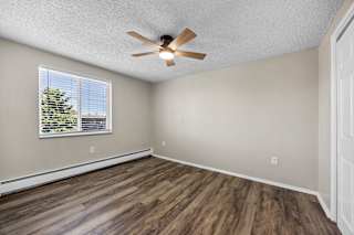 A room with a ceiling fan and a window with blinds.
