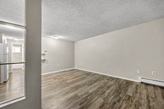 A room with wooden flooring and white walls.