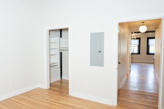 A room with a white wall and a wooden floor.