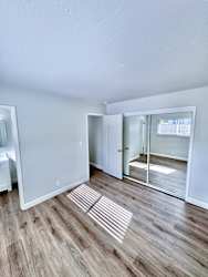 a living room with a hard wood floor and a sliding glass door