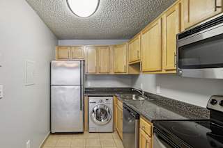 a kitchen with a sink and a refrigerator and a washing machine