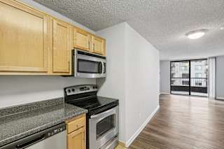 the kitchen of an apartment with wood cabinets and stainless steel appliances