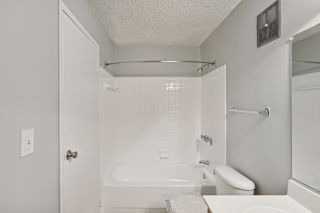 a white bathroom with a tub and a sink