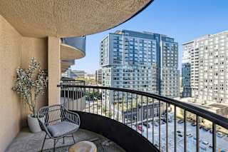 a balcony with a view of a city and a chair