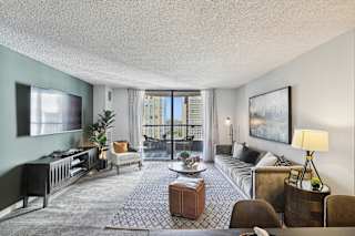a living room with a couch and a tv and a balcony