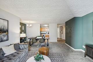 the living room and dining room of an apartment with a couch and a table