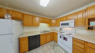A kitchen with wooden cabinets and white appliances.