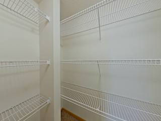 Empty white shelves in a pantry.