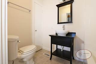 A bathroom with a toilet, sink and shower over tub.
