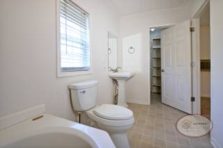 The master bathroom with sink, toilet, and large tub.