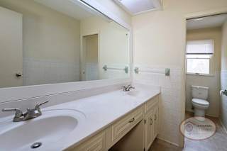 A bathroom with a white sink and a toilet.
