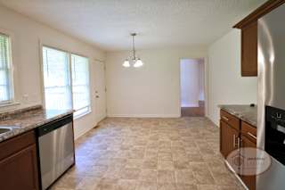 A spacious kitchen with dining area and large windows.
