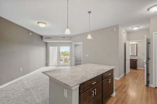 A spacious kitchen with a granite countertop and wooden cabinets.