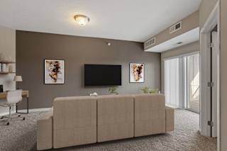 A living room with a couch, a television, and a chair.