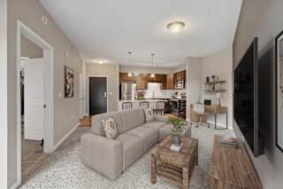 A living room with a grey couch, a wooden coffee table, and a flat screen TV.