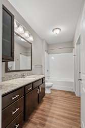 A bathroom with a sink, mirror, and toilet.