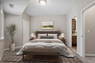 A bedroom with a large bed and a painting on the wall.