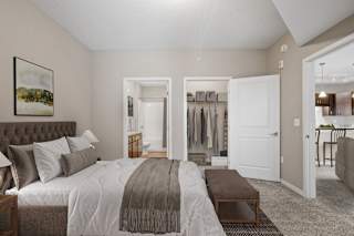 A bedroom with a large bed and a painting on the wall.